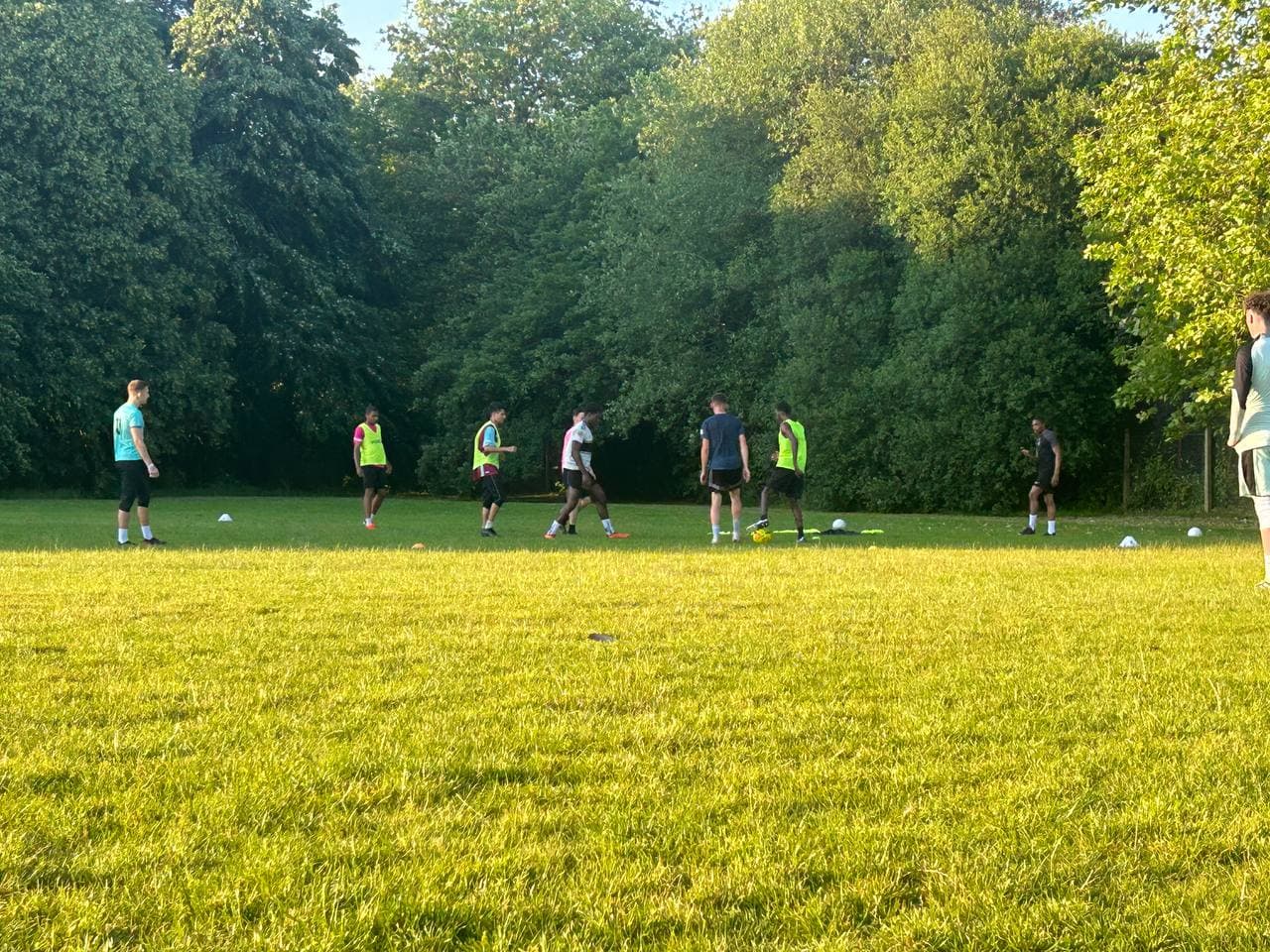 Community football match taking place on the grass at Roots & Wings 2024