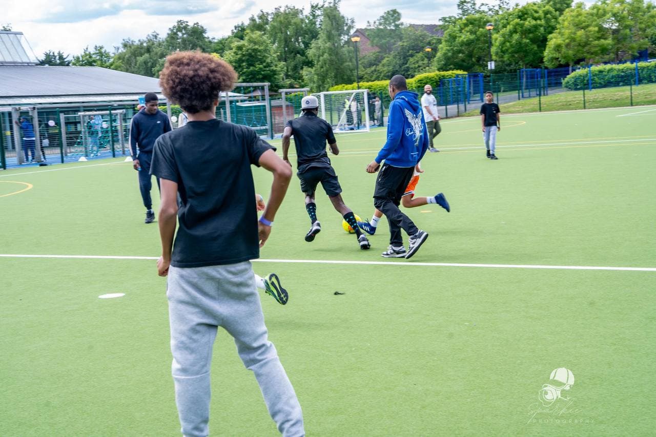 Young people playing a football match at Roots & Wings 2024