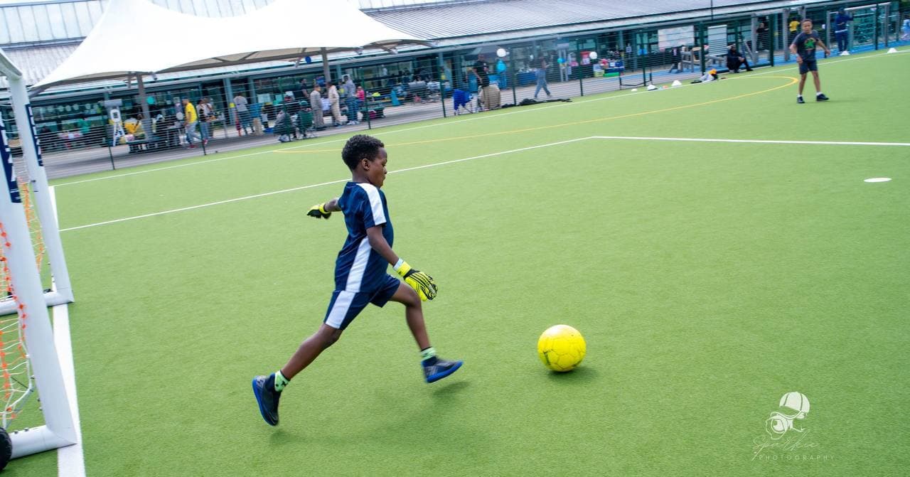 Young person running with the ball during Roots & Wings 2024