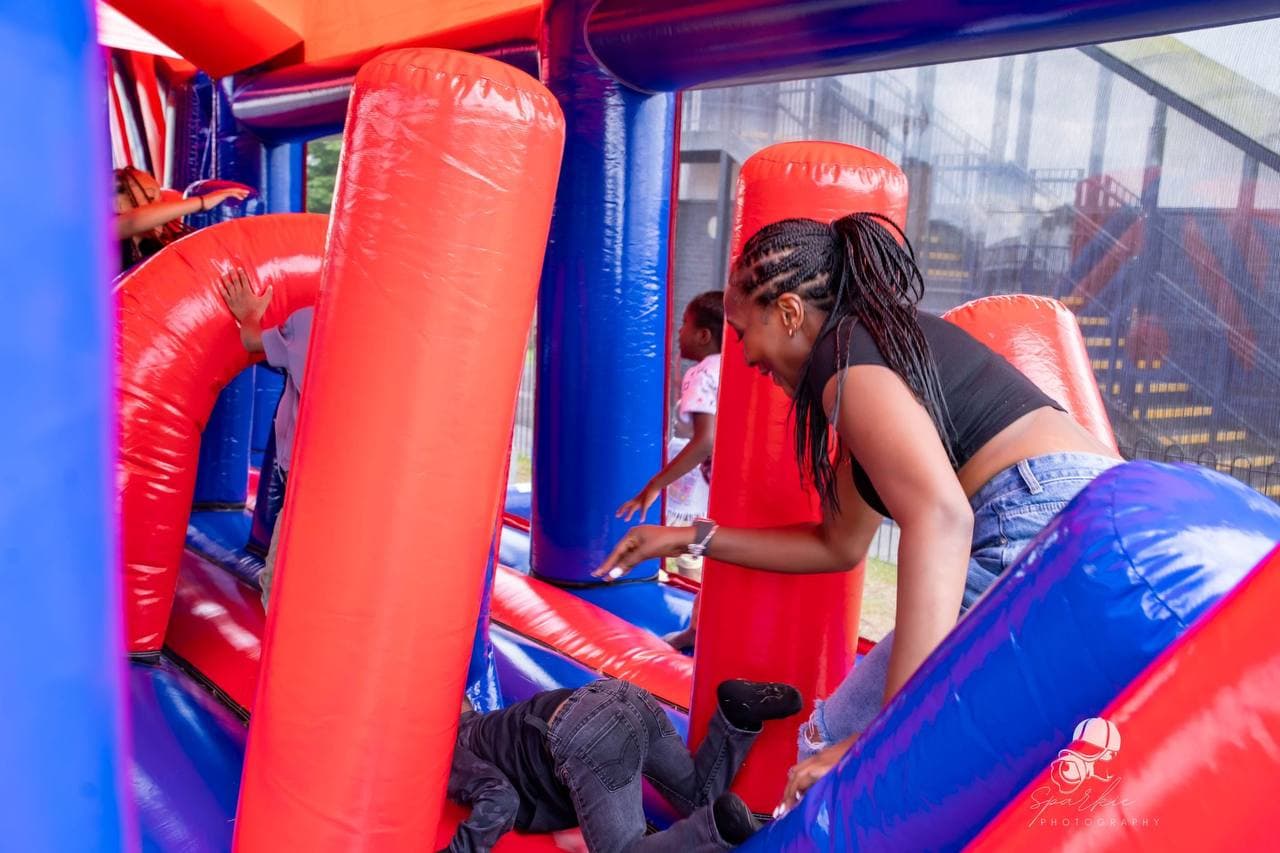 Children enjoying the inflatable play area at Roots & Wings 2024