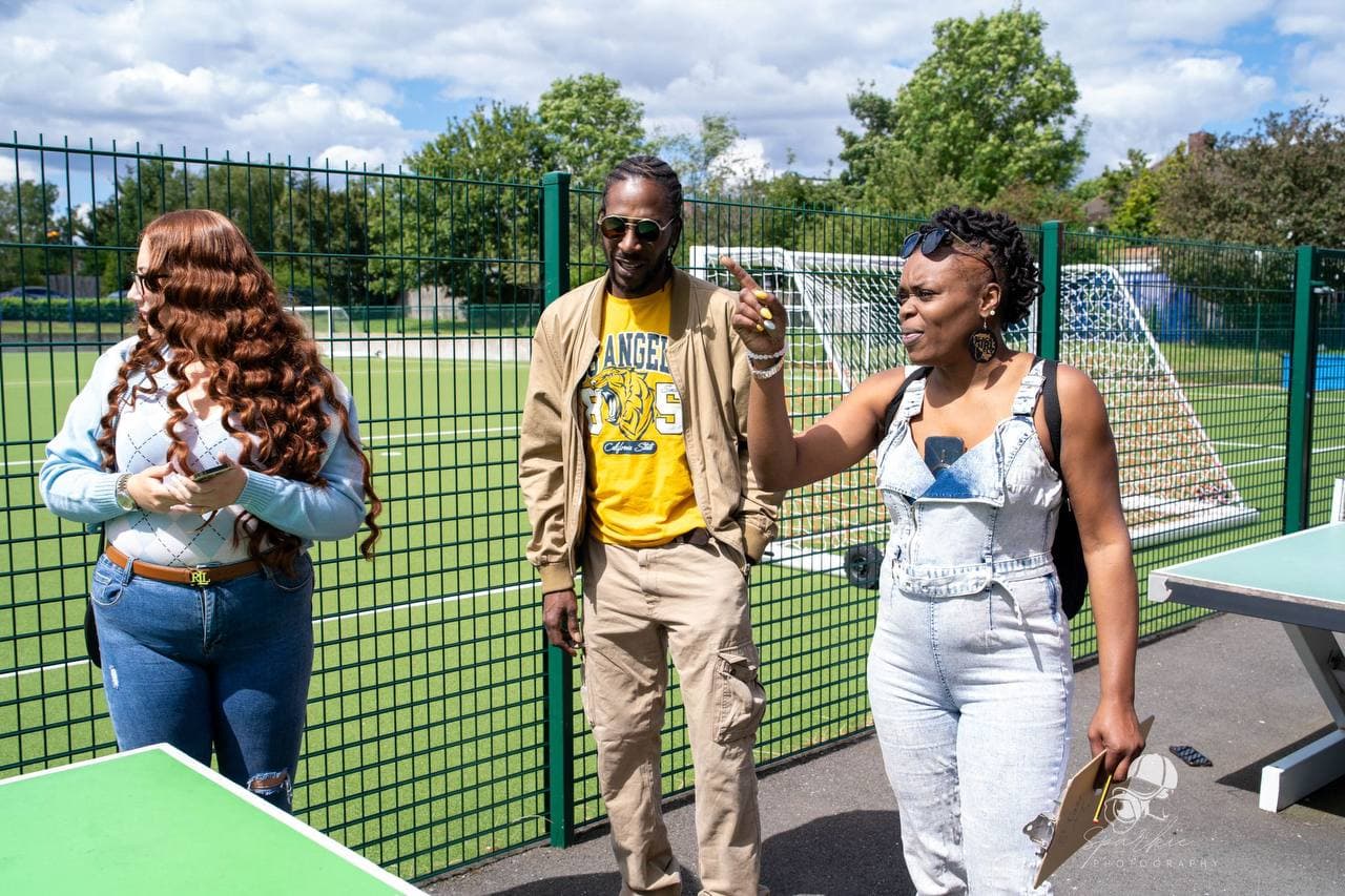 Community members being interviewed beside the football pitch at Roots & Wings 2024