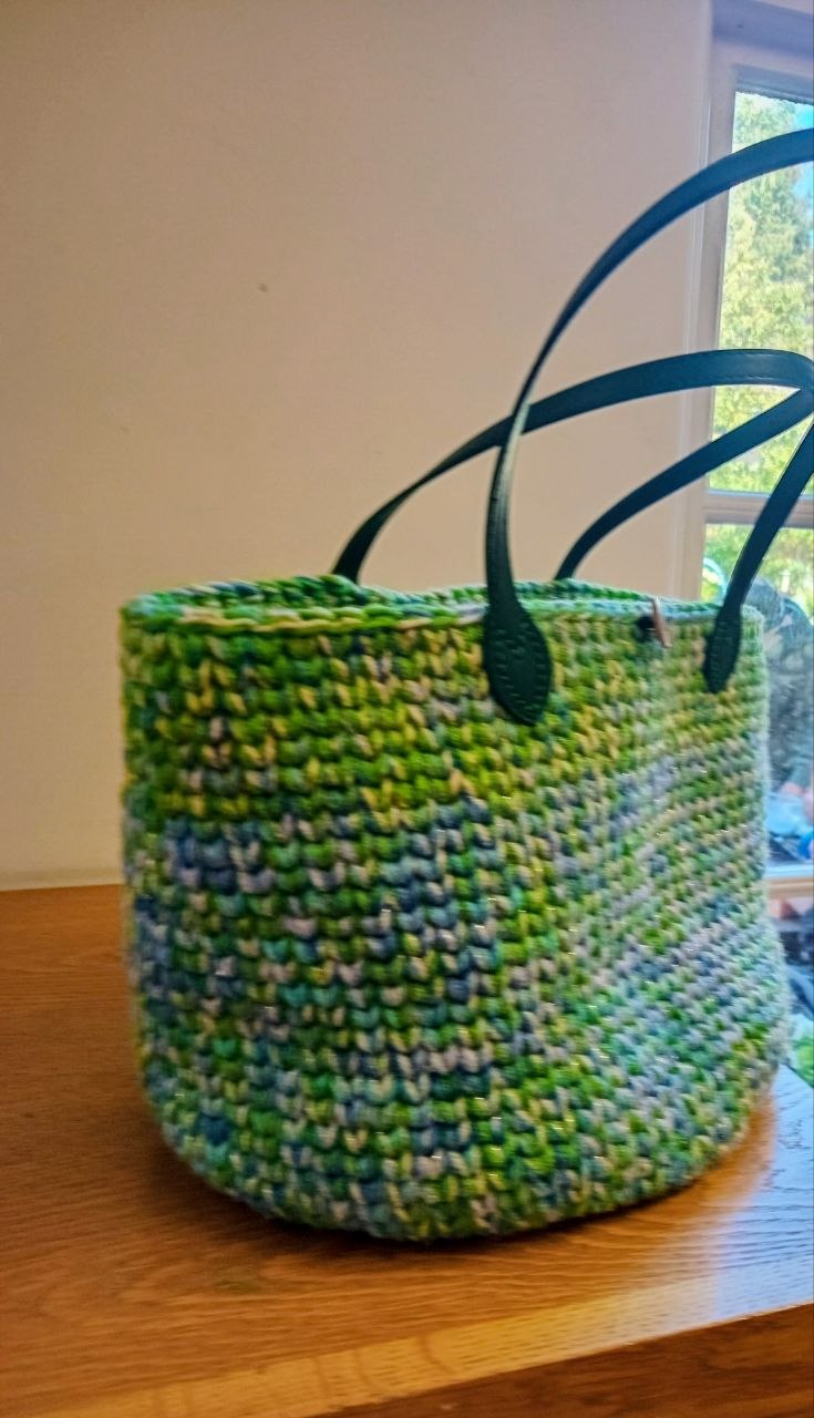 Green and blue crochet basket bag with dark handles made by a Stitch Craft N Knit group member