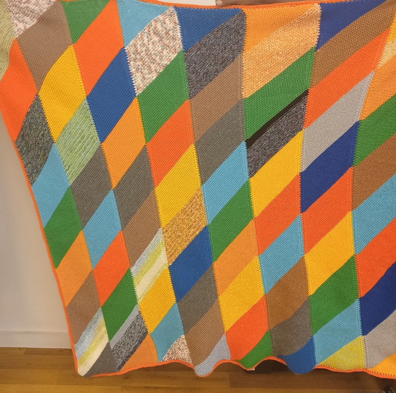 Colourful completed knitted blanket made with different double knitting yarn