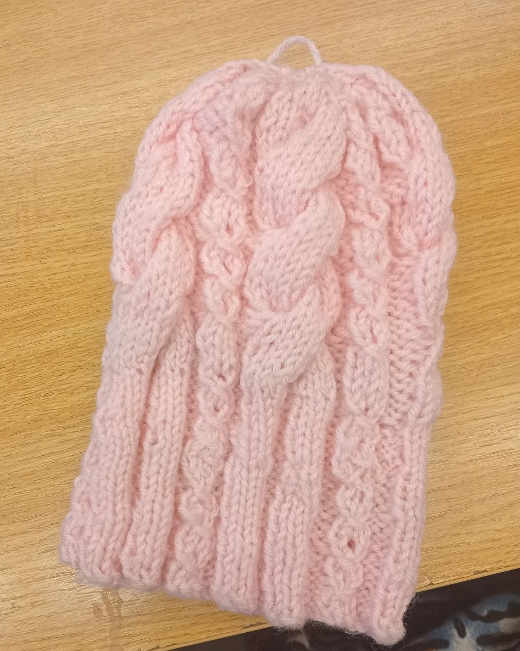 Soft pink knitted hat finished by a Stitch Craft N Knit group member